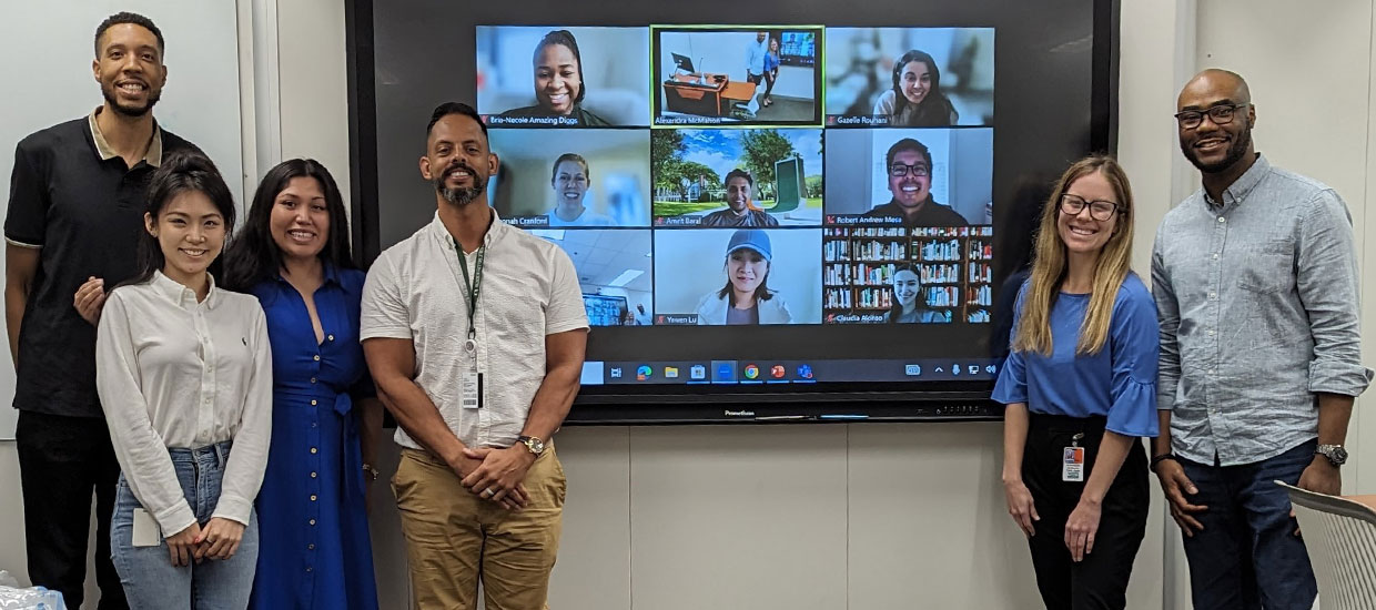 Group members of EJC standing together in front of a video conference call