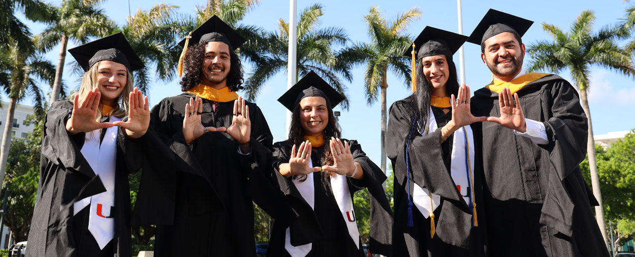 Diverse group of graduates waving the "U" symbol