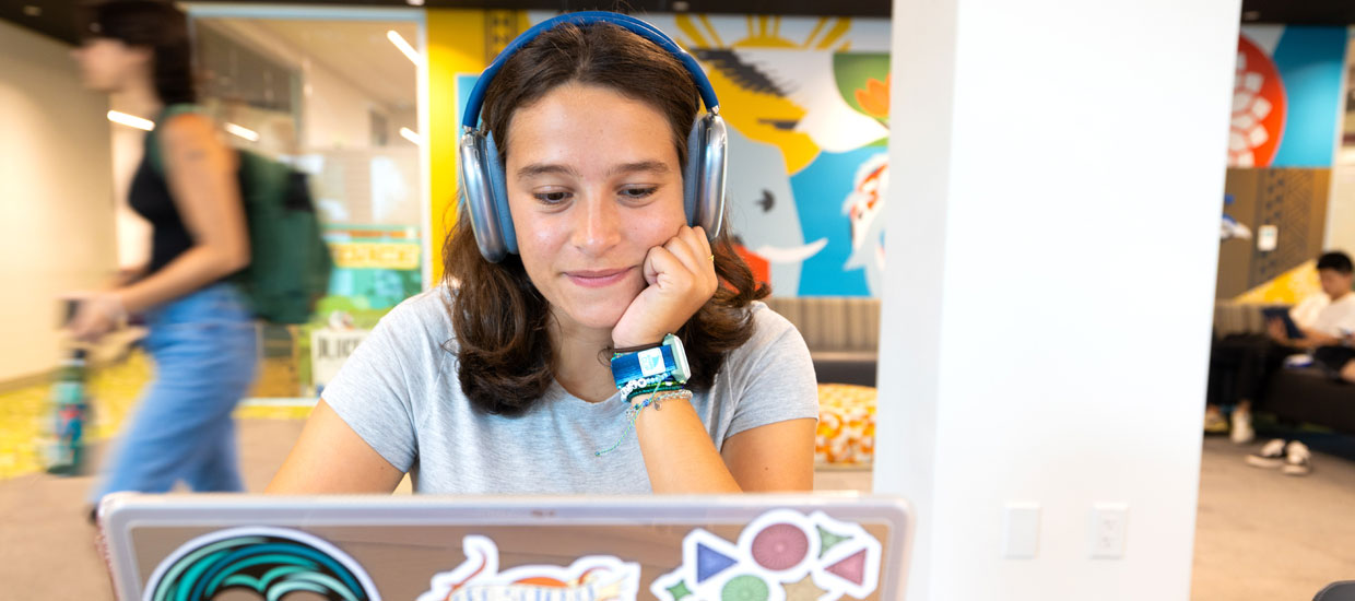 Student with headphones on laptop computer