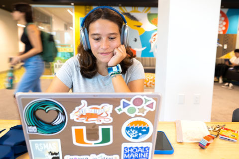 Student with headphones on laptop computer