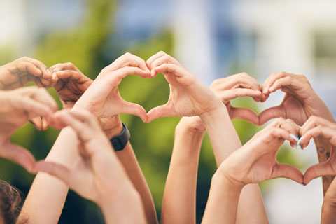 group of hands in the air making heart shapes
