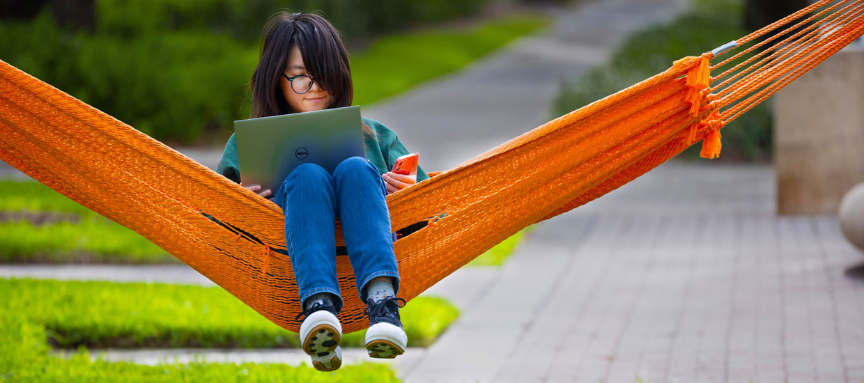 student on swing with laptop