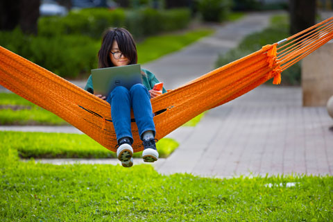 student on swing with laptop