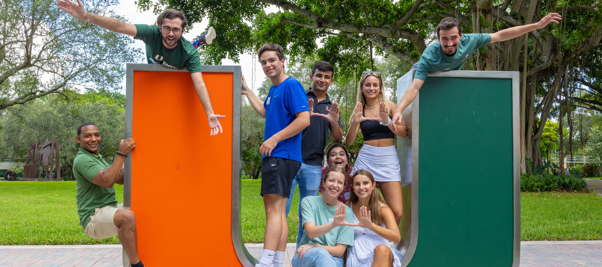 Students posing by UM sculpture