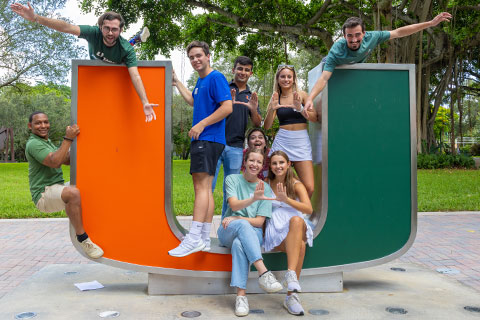 Students posing by UM sculpture